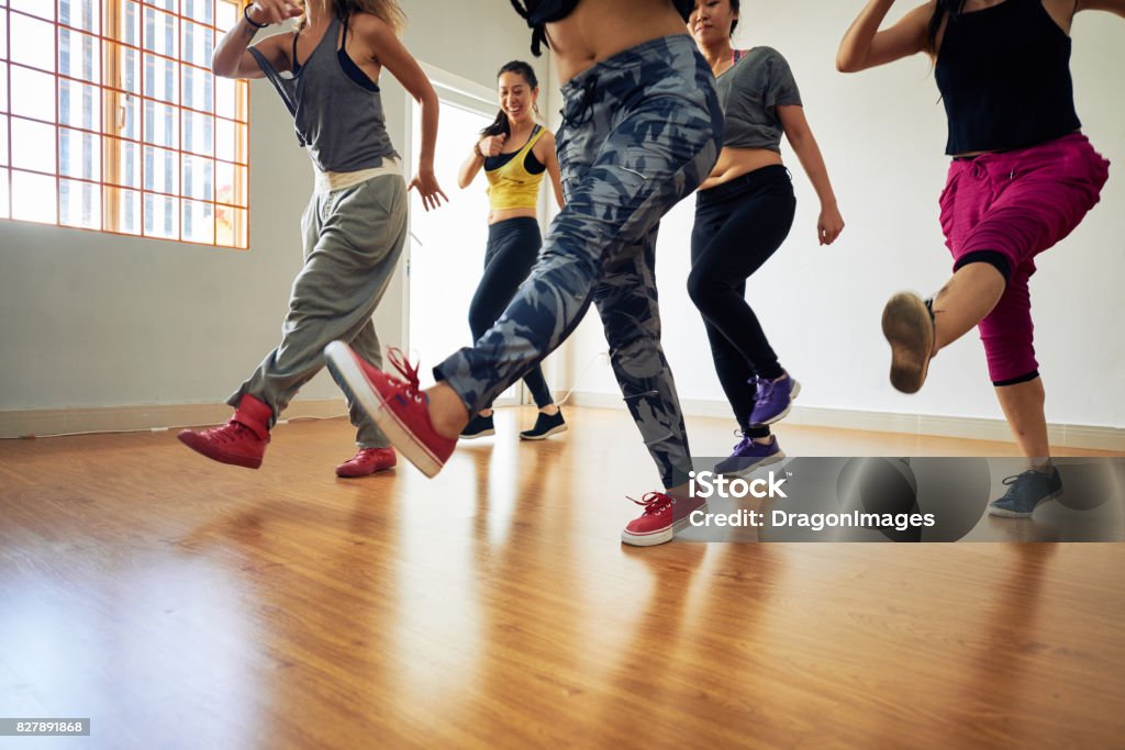 Sporty women enjoying each others company while doing leg swings during fitness training